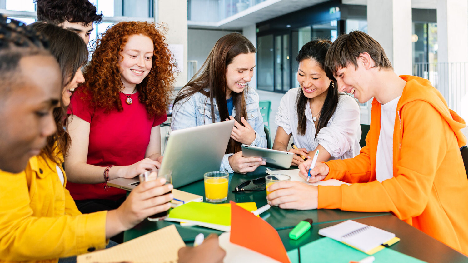 Gruppe Schülerinnen und Schüler arbeitet gemeinsam an einem Schülerprojekt