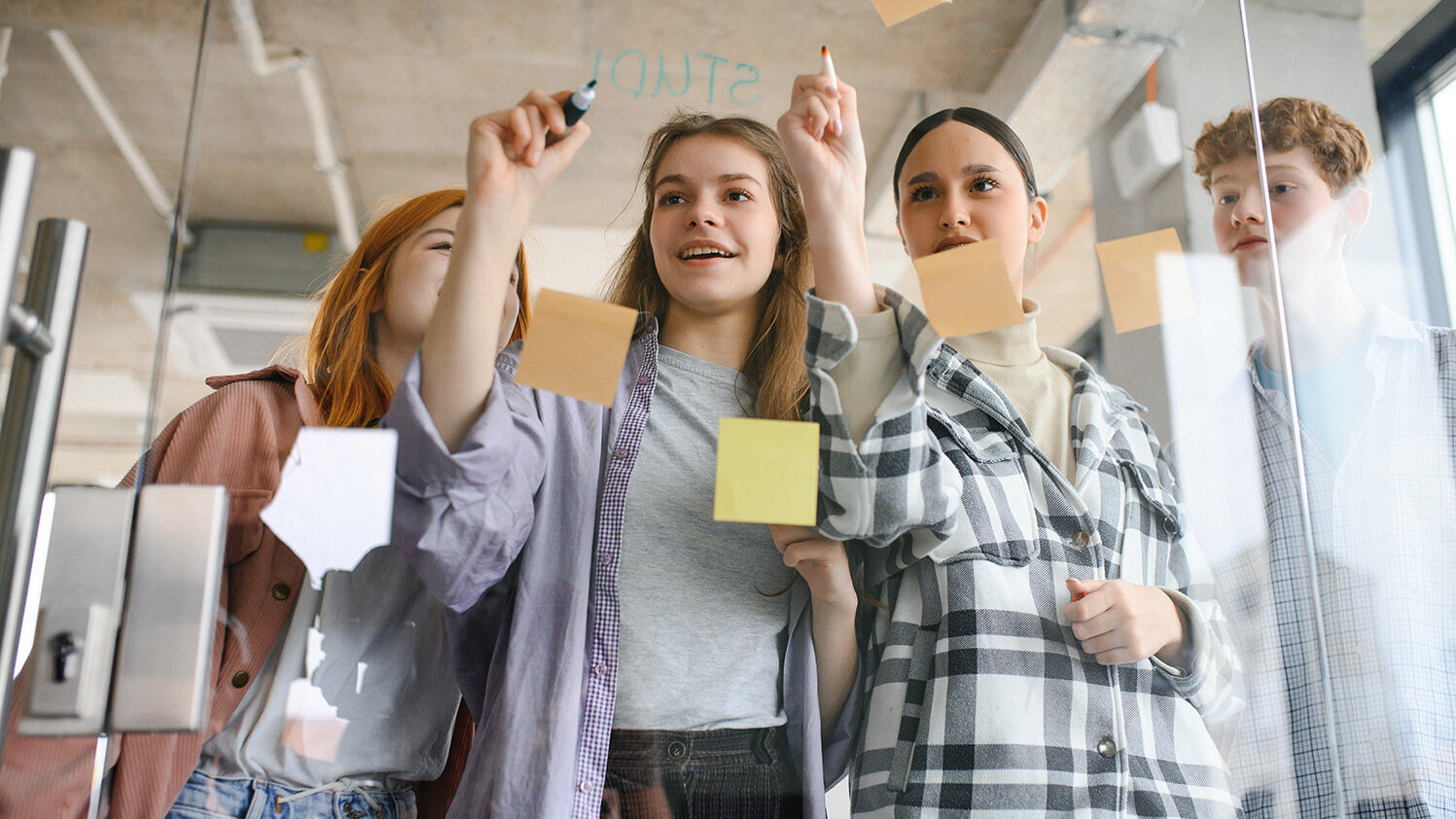 Schülergruppe macht Notizen auf Post-its