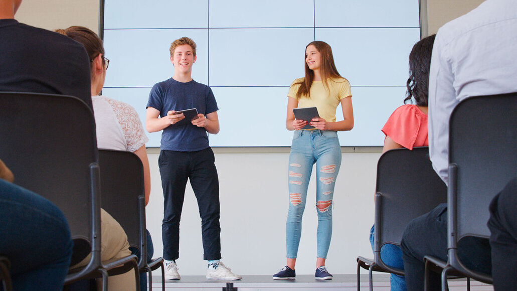 Zwei Schüler auf einer Bühne bei einer Präsentation