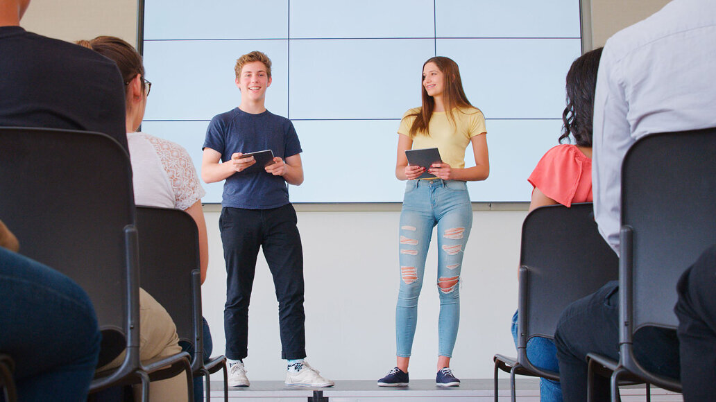 Zwei Schüler auf einer Bühne bei einer Präsentation