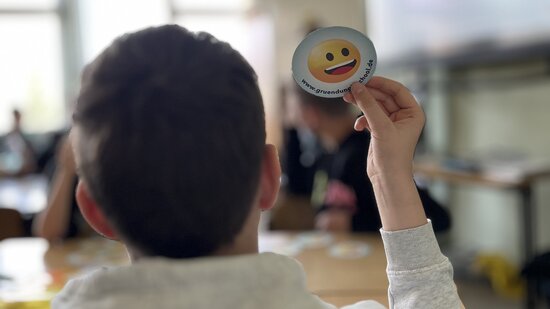 Schüler hält Karte hoch First Start-up Experience